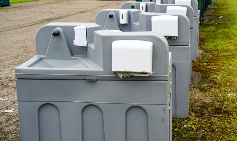 Portable-wash-stationed-lined-up Gray portable washing stations lined up