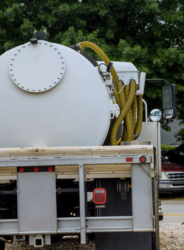 White septic truck in front of a residence